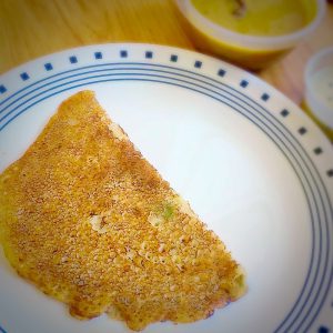 Instant wheat dosa served hot with coconut chutney on a rustic banana leaf plate, showcasing its golden crisp edges and lacy texture.