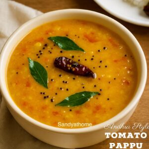 A bowl of Andhra-style tomato pappu served with steamed rice and ghee on a rustic plate