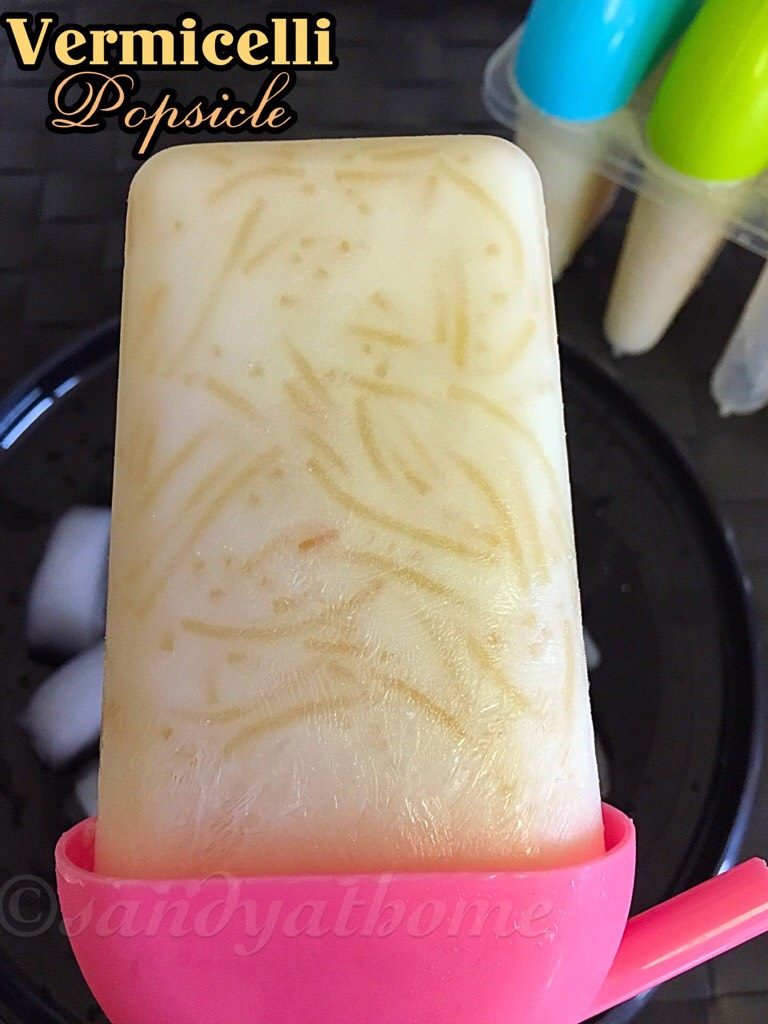 Creamy South Indian Semiya Ice popsicles with vermicelli strands, served on a brass plate with ice cubes for a rustic summer look.