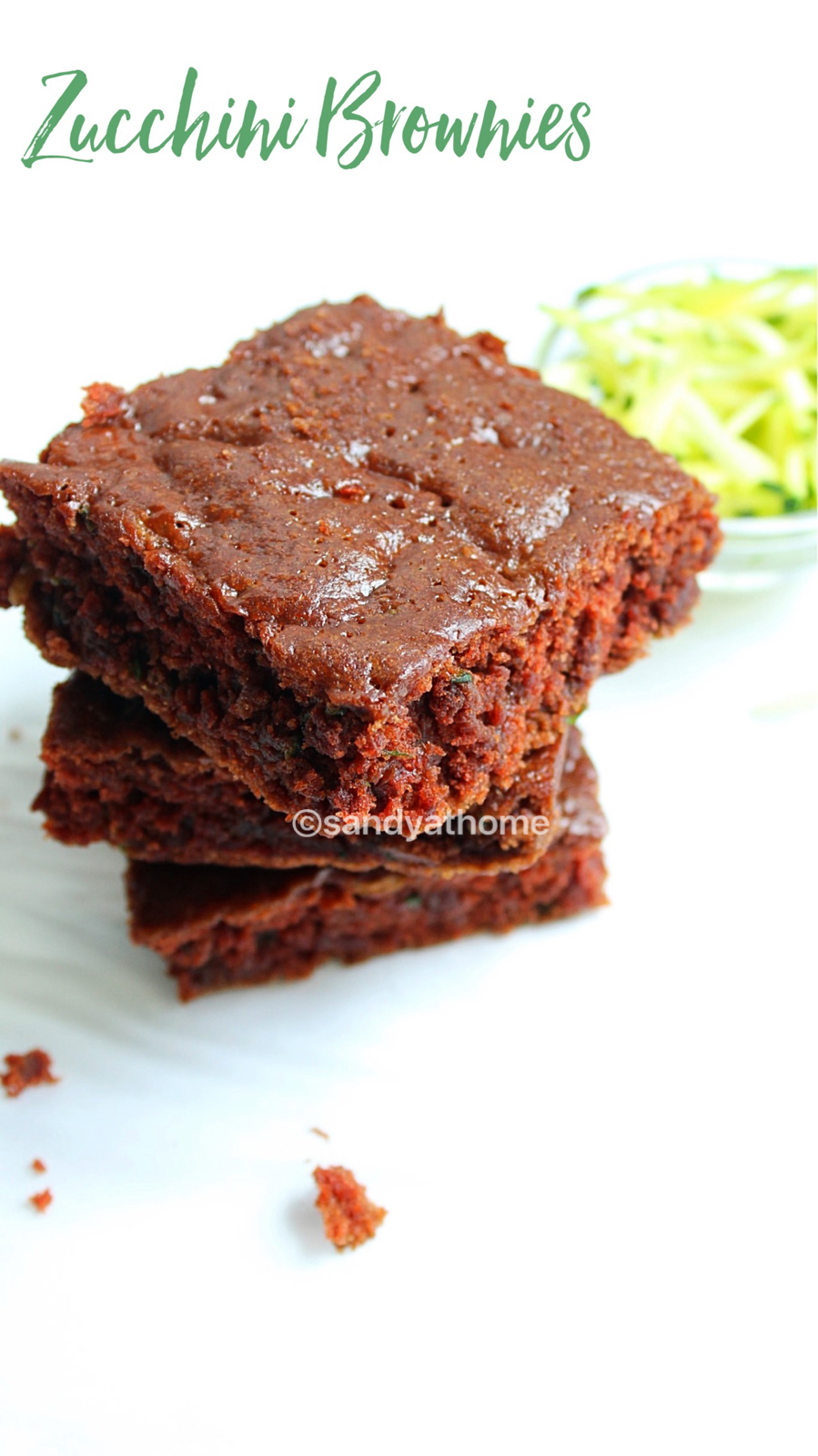 A soft, chocolatey eggless brownie made with zucchini, served on a white plate with crumbs around
