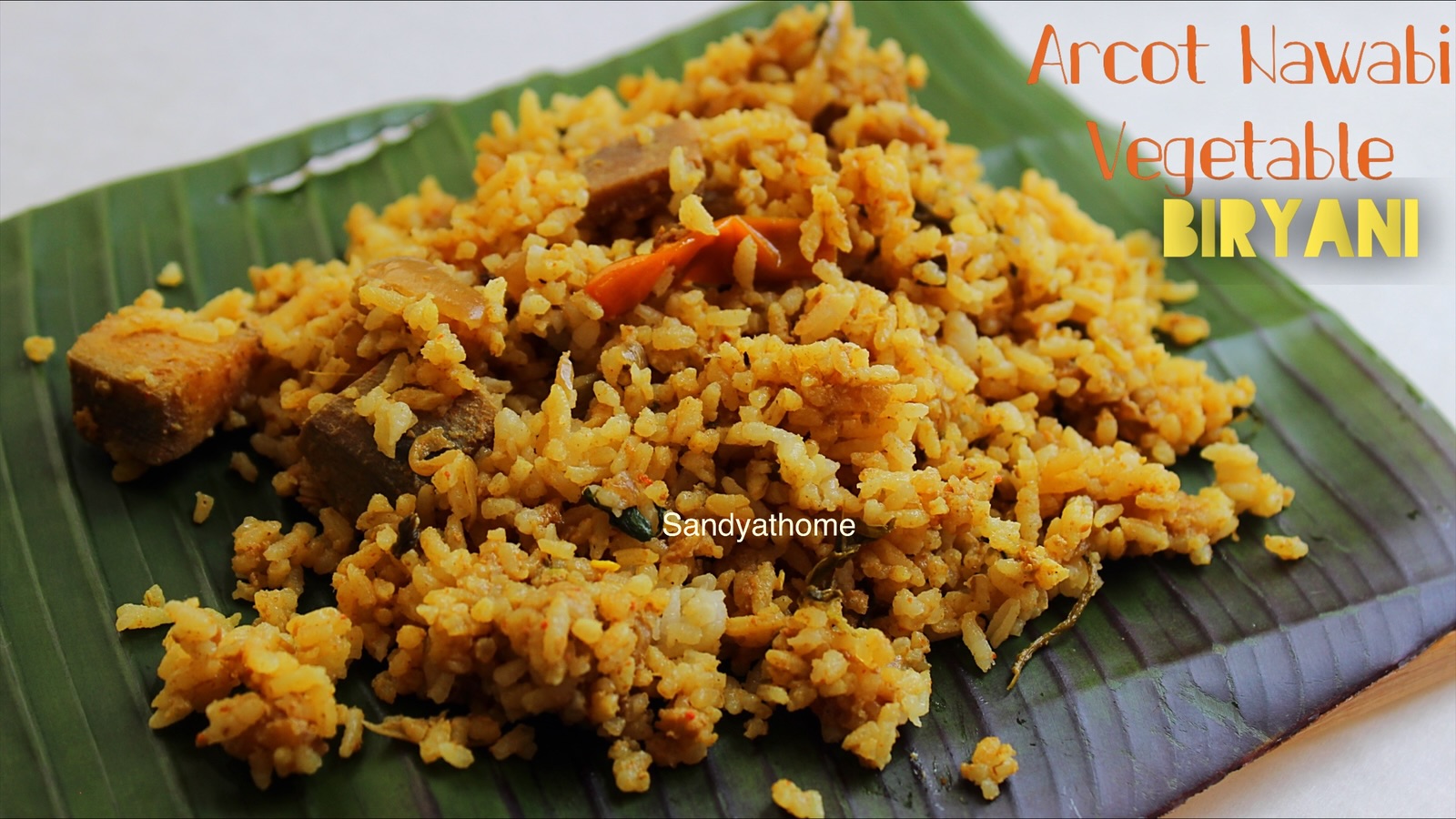 Close-up of Arcot Nawabi Biryani with fluffy jeeraga samba rice topped with fried onions, mint, and rose petals for a royal finishing touch.