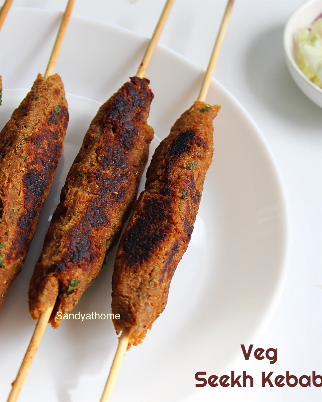 Pan-cooked soya seekh kebabs with potato, served hot on a rustic plate with lemon and chutney
