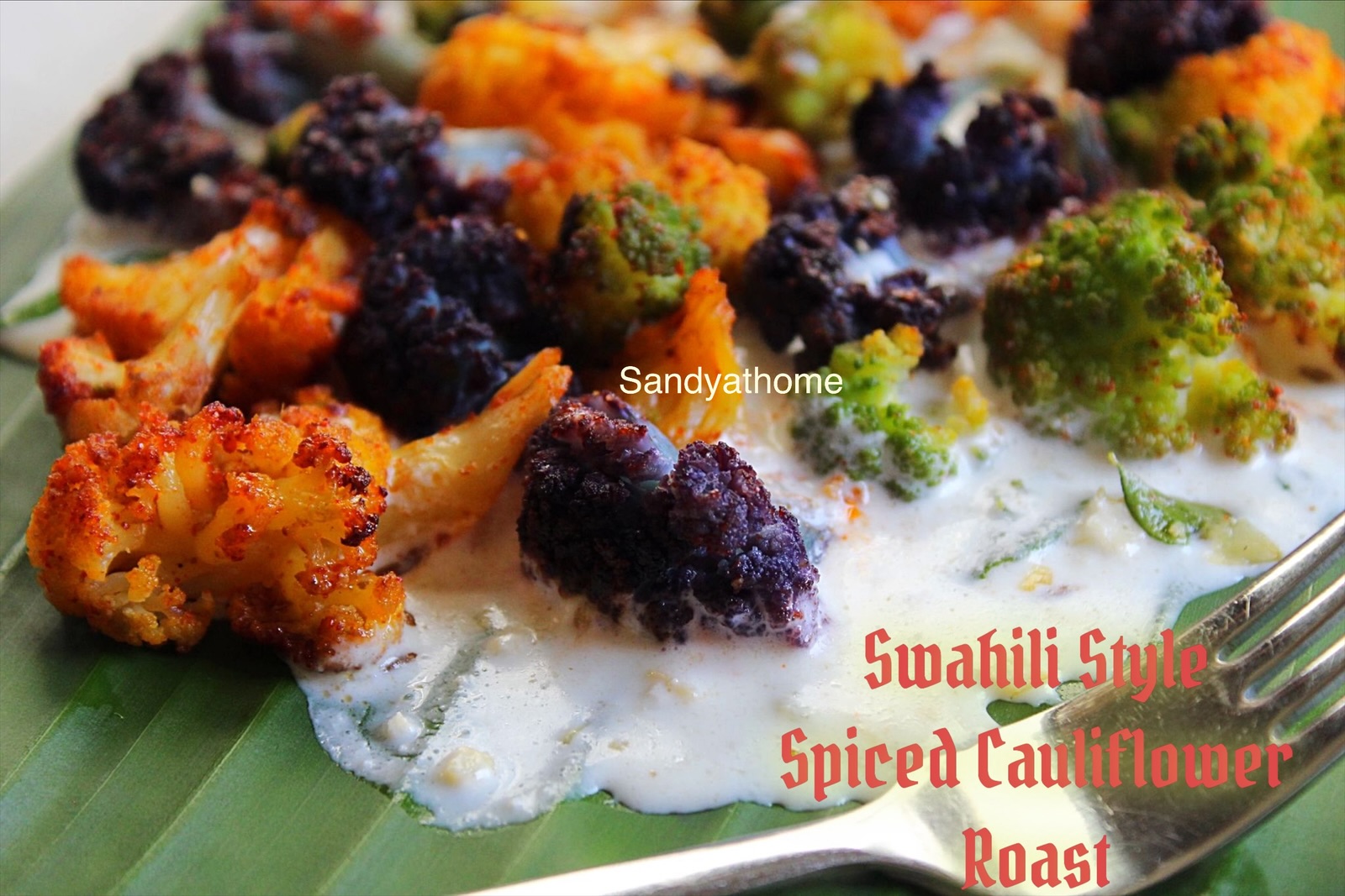 Swahili-inspired Indian fusion dish featuring roasted colorful cauliflower on banana leaf, served with creamy cashew curd white sauce; healthy Trader Joe’s cauliflower recipe with spices like cumin and garlic, plated as a vibrant African Indian appetizer or starter.