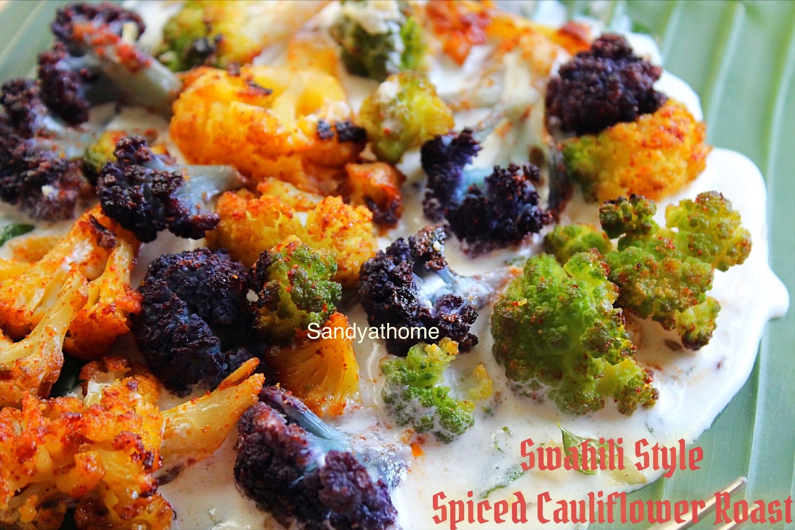 Swahili-inspired Indian fusion dish featuring roasted colorful cauliflower on banana leaf, served with creamy cashew curd white sauce; healthy Trader Joe’s cauliflower recipe with spices like cumin and garlic, plated as a vibrant African Indian appetizer or starter.
