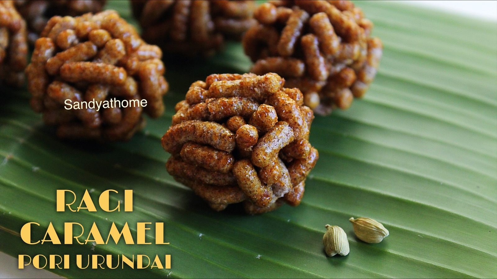Golden caramel-coated ragi pori urundai with sukku arranged for a festive recipe display.