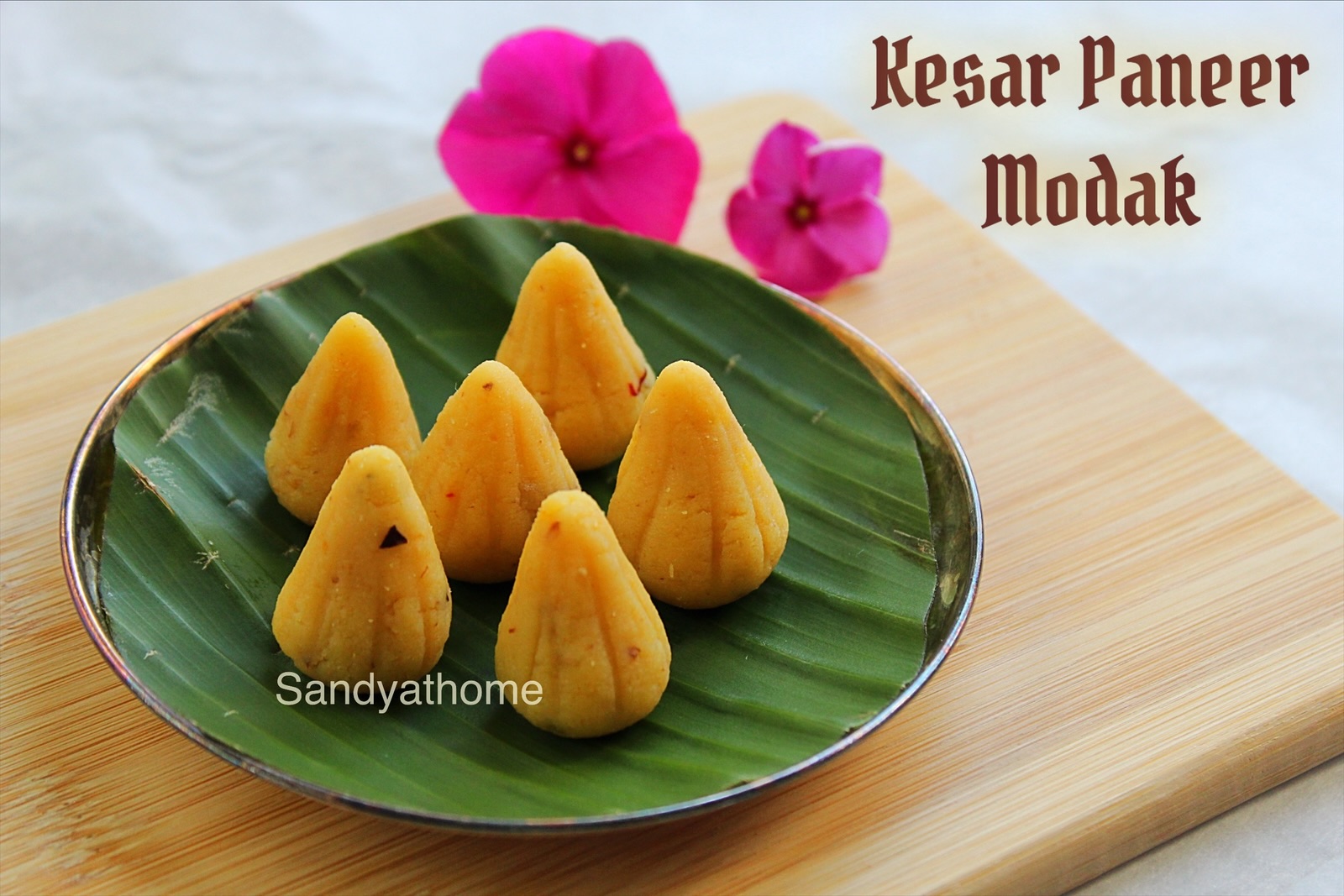 Handmade paneer kesar modak placed on banana leaf for Ganesh Chaturthi offering.