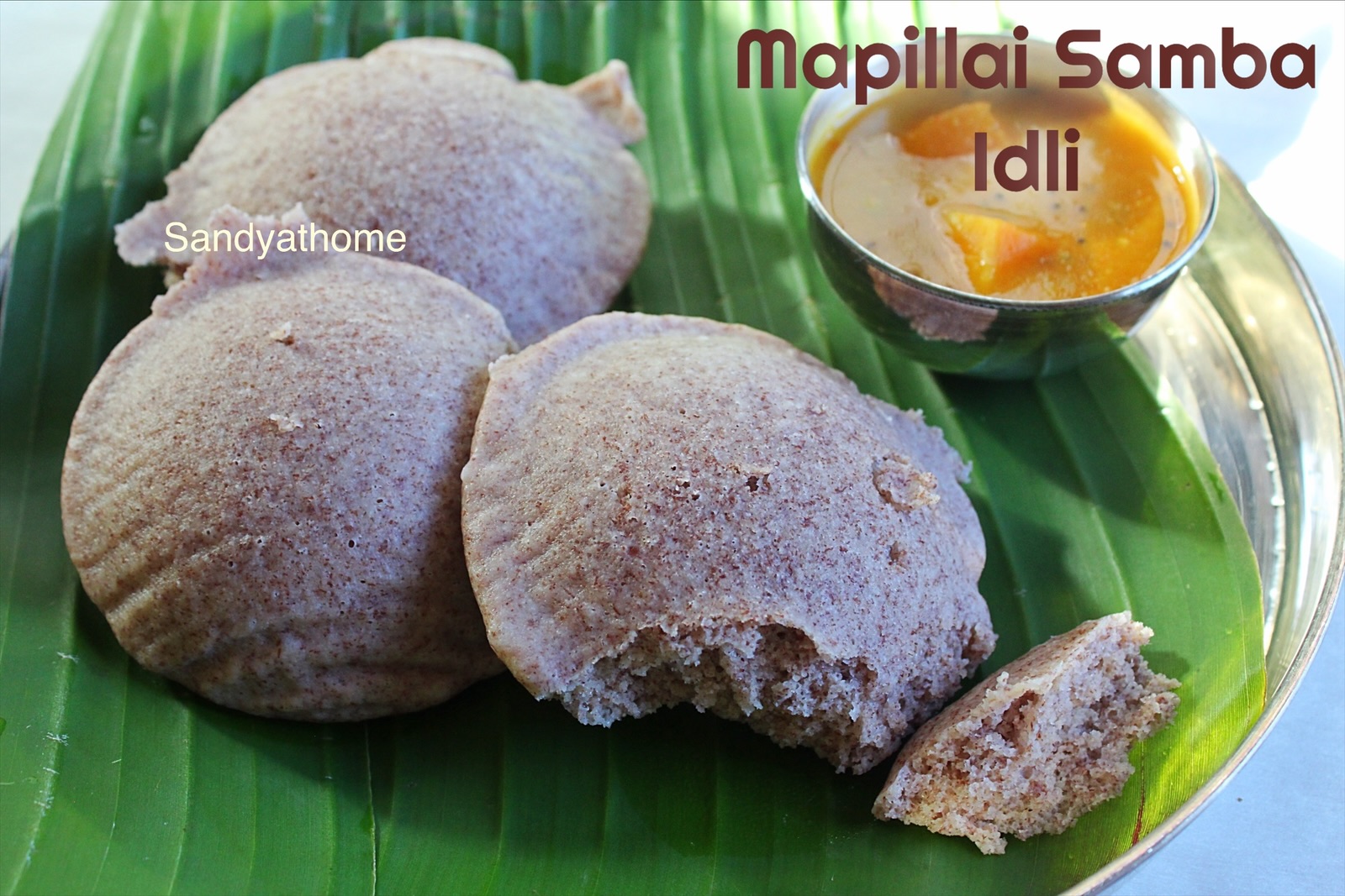 Red rice idlis made from Mapillai Samba, paired with coconut chutney and traditional podi for serving.