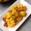 Chinese-American style honey walnut shrimp on a serving platter topped with candied walnuts and a drizzle of honey.