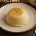 Traditional Indian junnu dessert made with instant mix, steamed to soft perfection and served with cardamom on a ceramic plate.