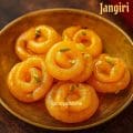 Close-up of golden mini jangiri made with turmeric, naturally colored South Indian sweet soaked in sugar syrup for Diwali.