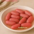 Close-up of rose-flavored rasgullas in sugar syrup, light and spongy paneer jamuns perfect for festive Indian sweets.