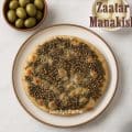Homemade zaatar manakish with a twist of cheese on top, golden brown and aromatic, served as a classic Lebanese street food flatbread.