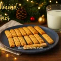 Crispy ghee almond fingers coated with chopped almonds served with milk on a Christmas background